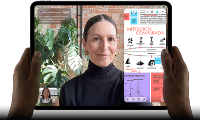 iPad Pro, parte delantera exterior, posición horizontal, color negro espacial, esquinas redondeadas, borde de la pantalla negro, dos manos sujetan los laterales izquierdo y derecho, la pantalla muestra una conversación de FaceTime con traducción en tiempo real y una app para aprender con una presentación sobre mitología comparada con texto, diagramas y notas escritas a mano